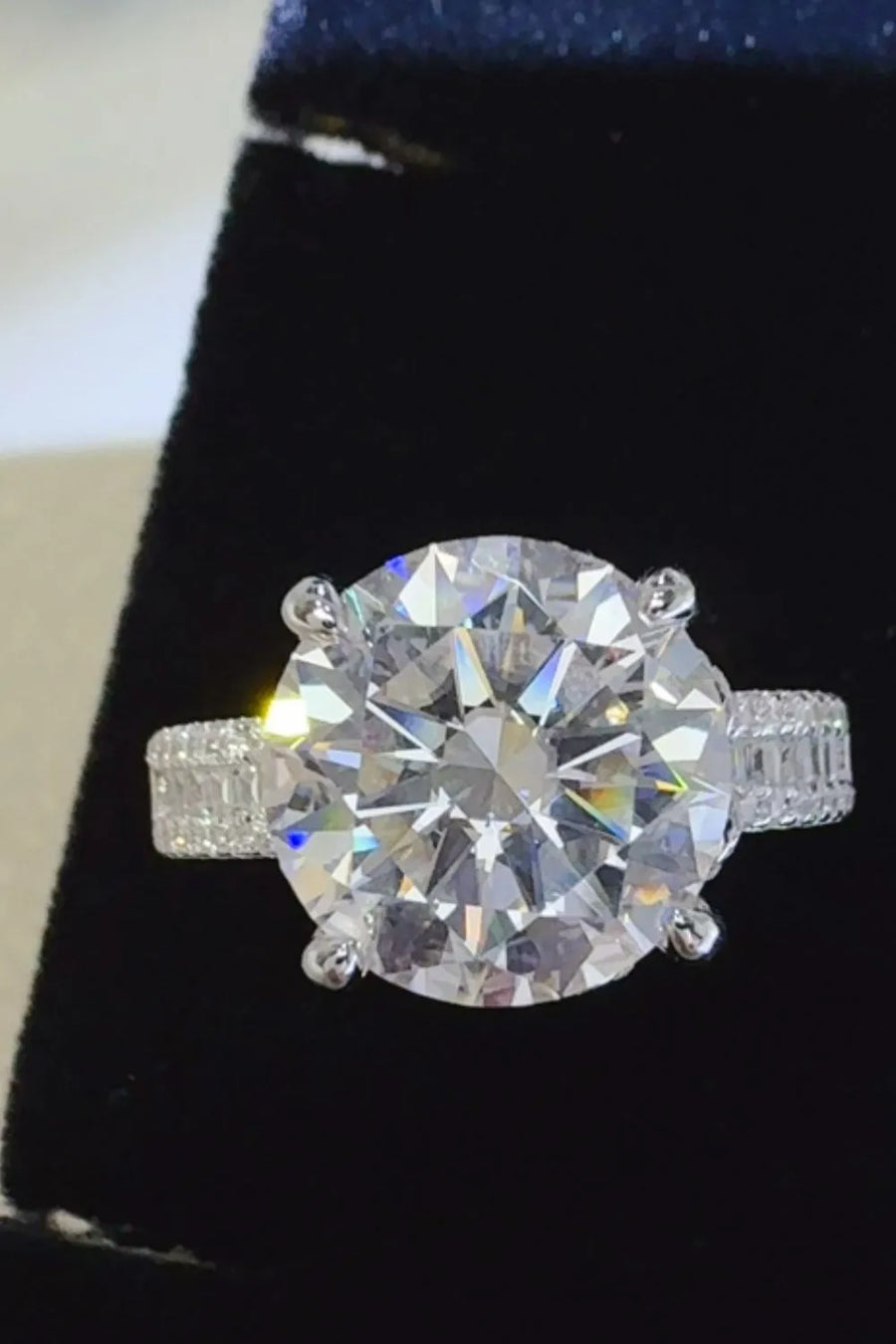Silver moissanite ring with large center stone and pavé band detail