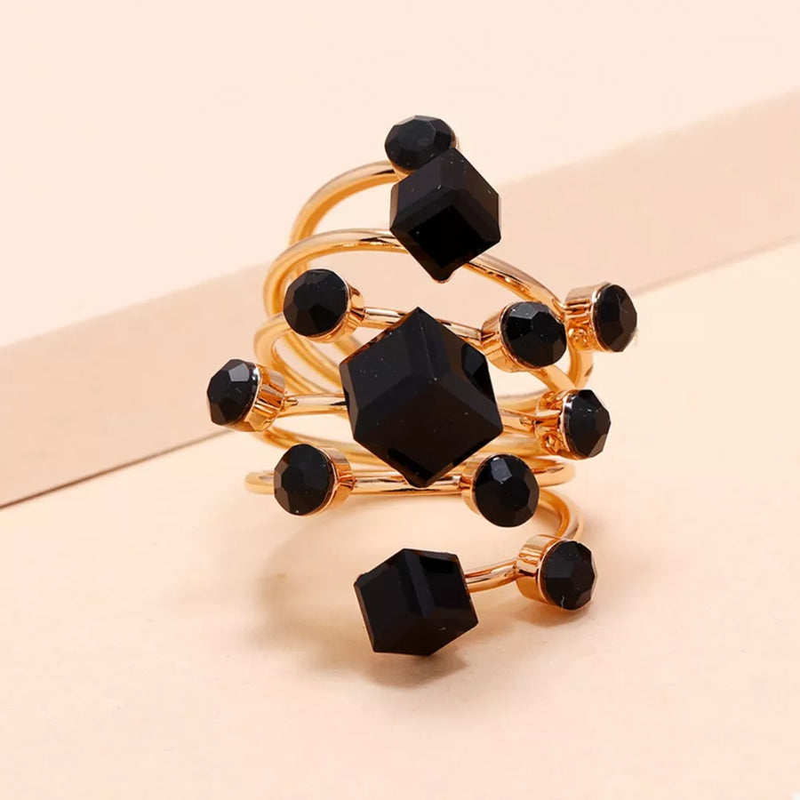 Gold-plated ring with black crystals and geometric shapes