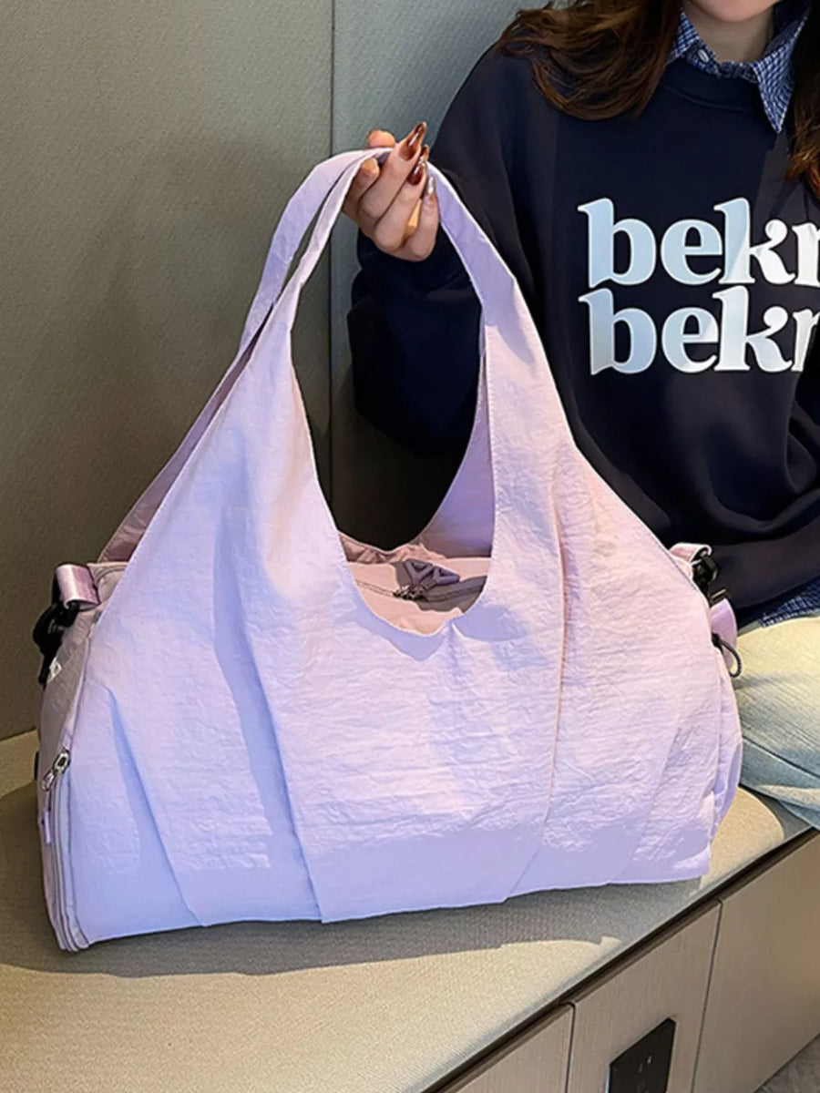 Lavender crinkled nylon duffel bag with top handles and zip closure.