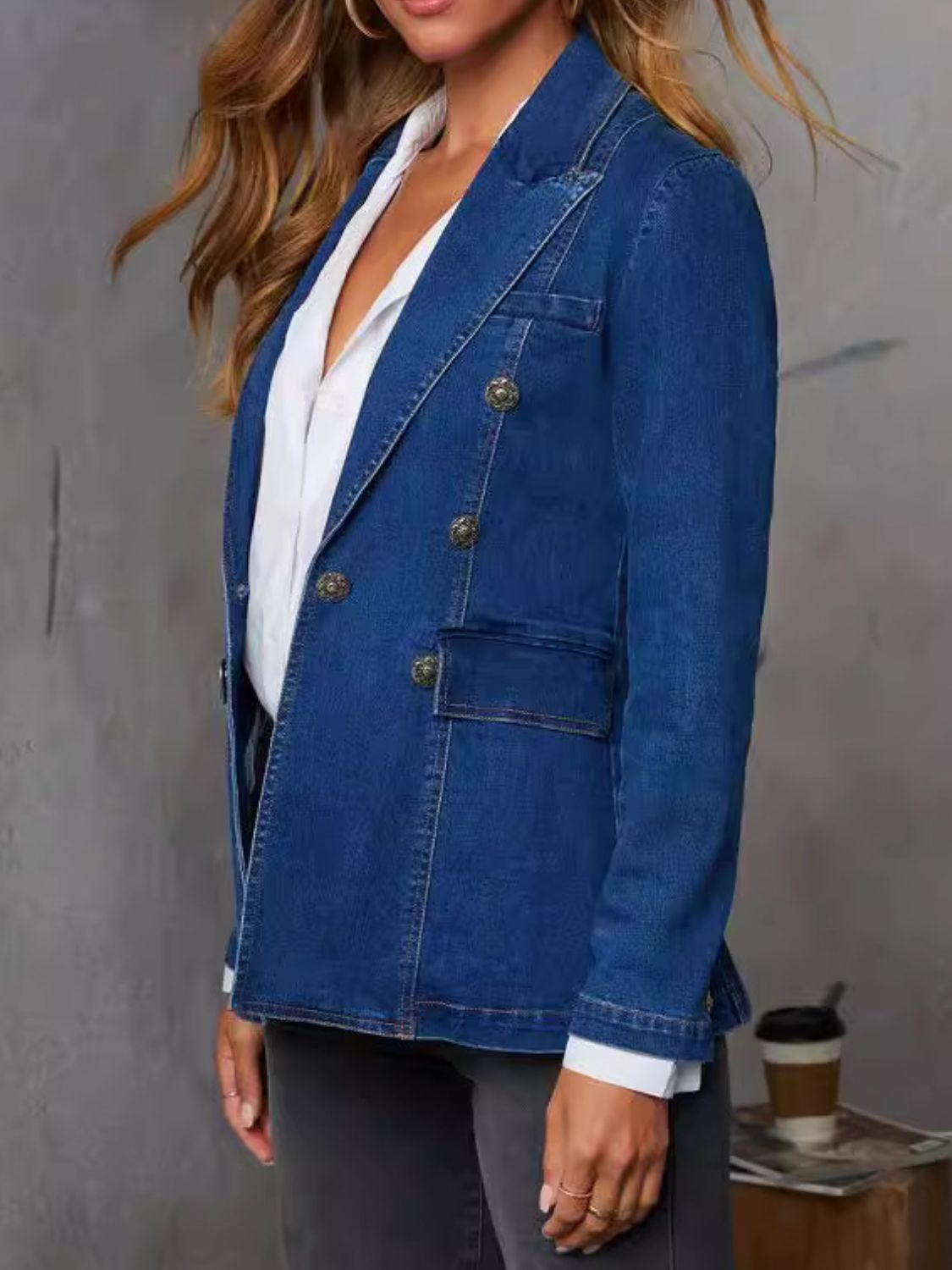 Dark denim double-breasted blazer with sculpted fit and ornate buttons.