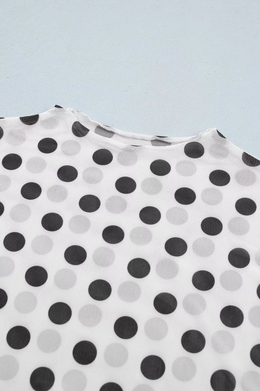 Chic polka dot mesh mock neck shirt in white with black and grey dots, sheer polyester fabric.