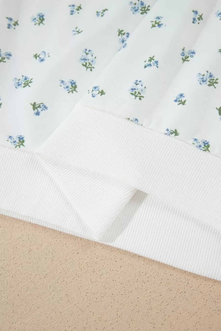 White sweatshirt with blue floral print and ribbed hem