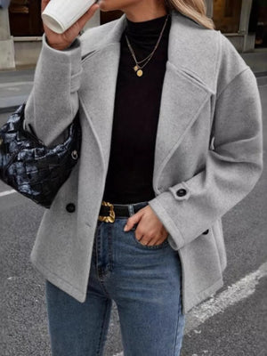Light gray double-breasted wool blend pea coat with black buttons and notched lapels.