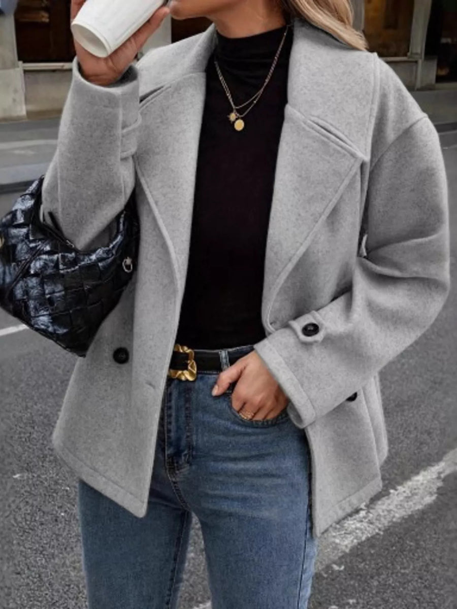 Light gray double-breasted wool blend pea coat with black buttons and notched lapels.