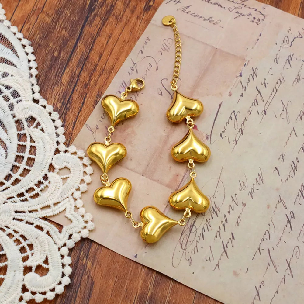 bracelet in gold featuring heart charms and straight fit