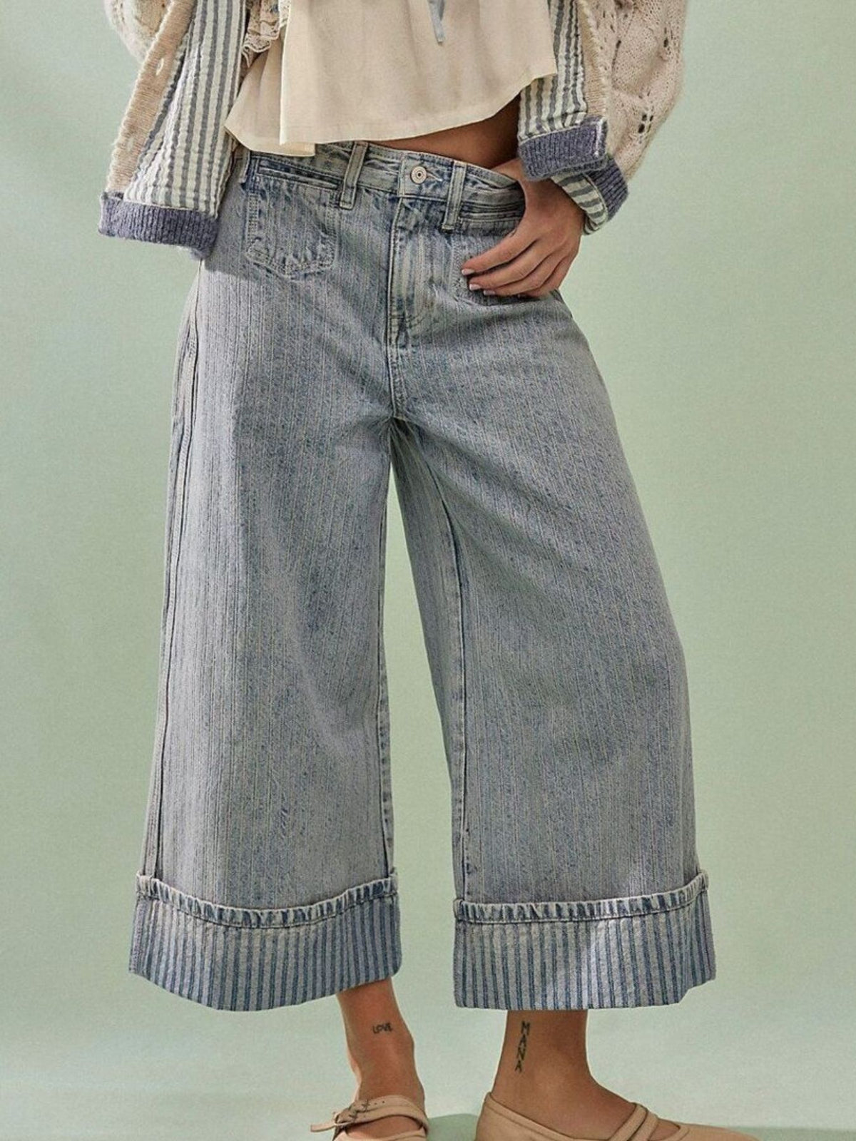 Light blue high-waisted cropped jeans with wide legs and striped cuffs.