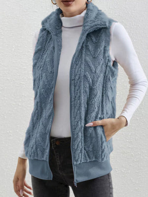 Blue faux fur zip-up vest with textured pattern and ribbed hem.