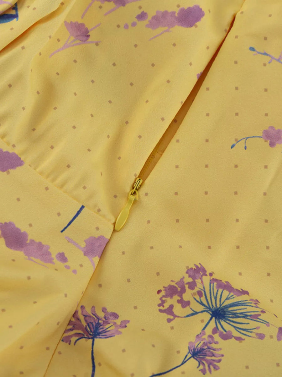 Yellow floral print dress with a zipper closure and subtle dot pattern.
