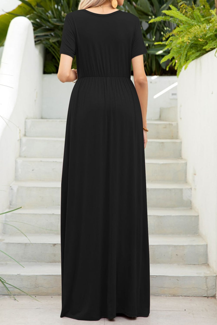 Black maxi dress with short sleeves, gathered waist, and pockets, shown from the back.