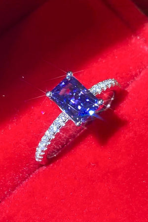 Blue emerald-cut sapphire ring with diamond band in 925 sterling silver.