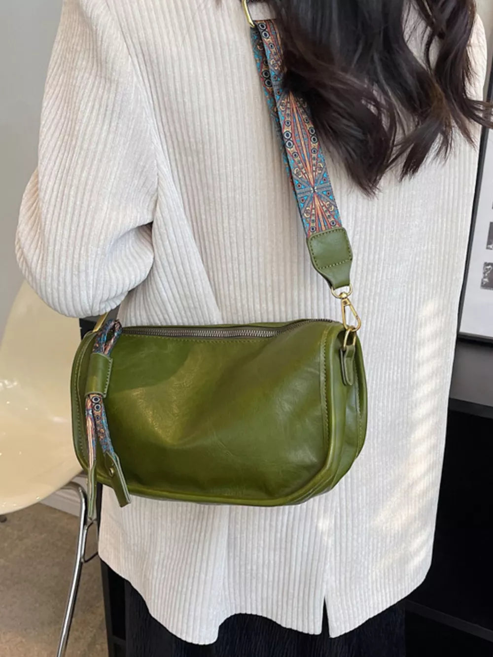 Green textured strap mini crossbody bag with adjustable strap and zipper closure.