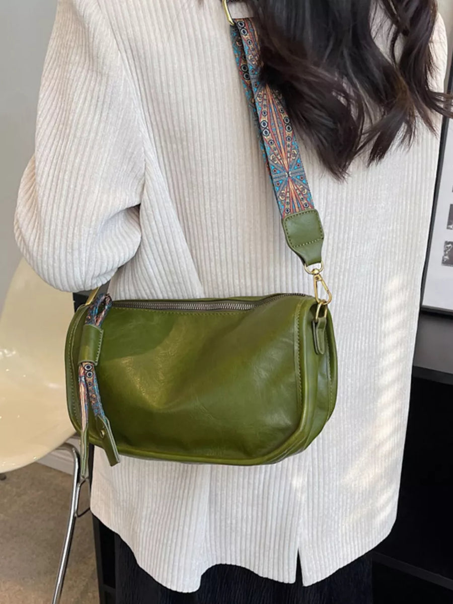 Green textured strap mini crossbody bag with adjustable strap and zipper closure.
