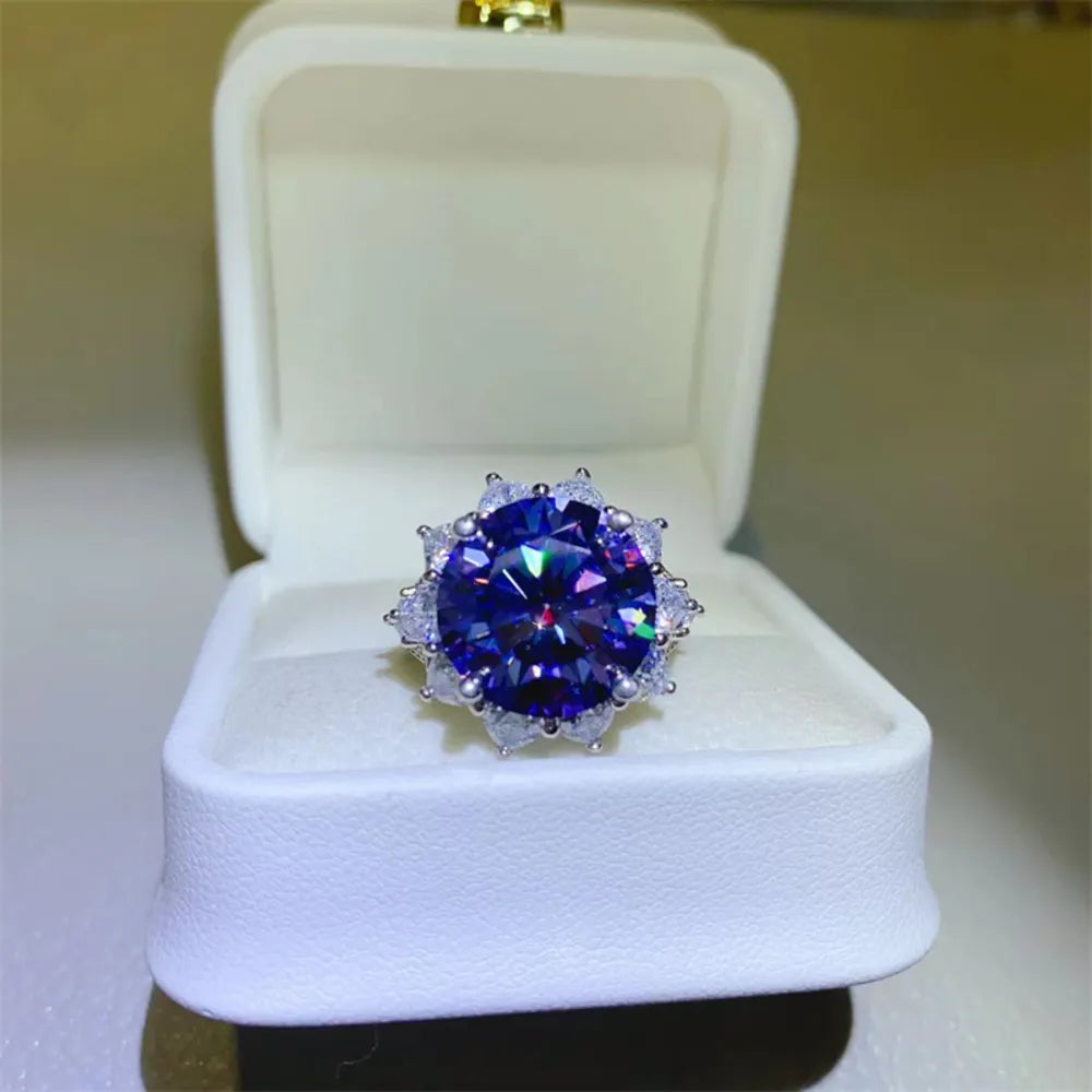 Dark blue moissanite cocktail ring in sterling silver with a halo of smaller stones.