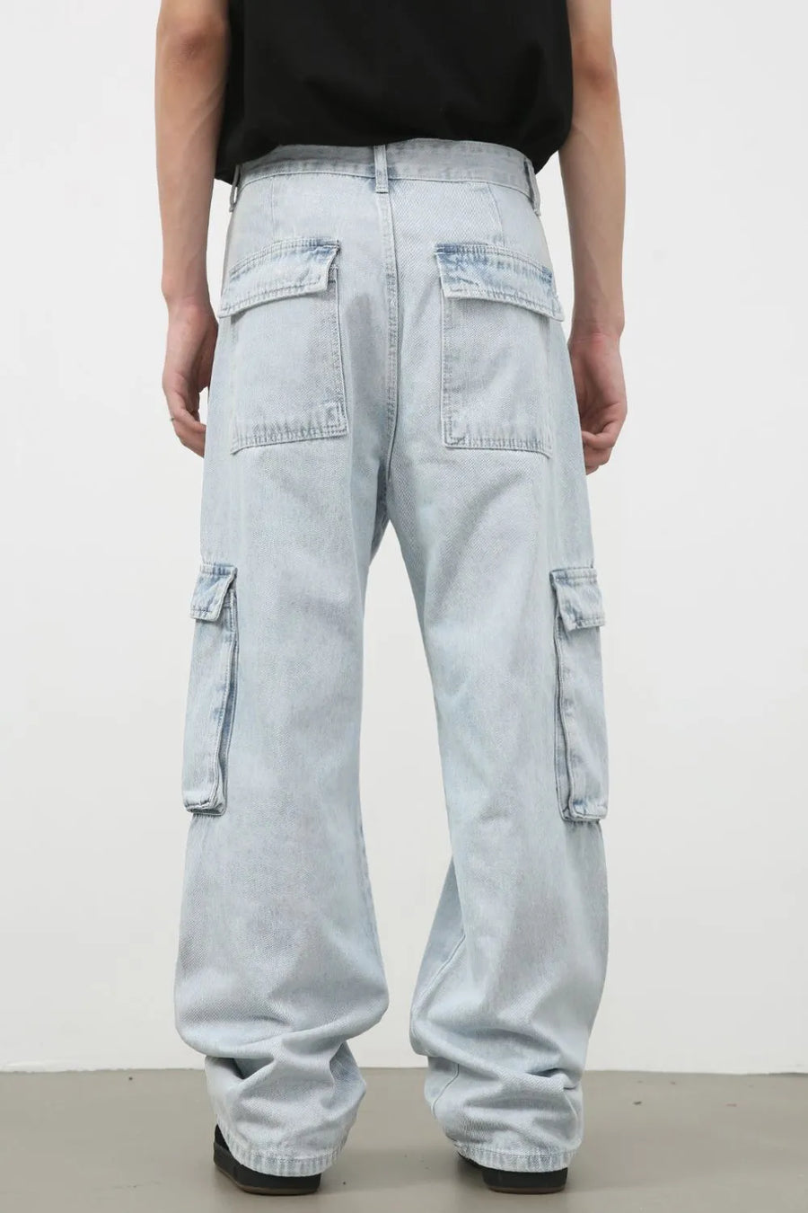 Oversized light wash denim cargo pants with multiple pockets and a relaxed fit.
