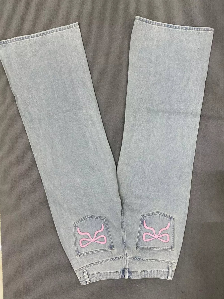 Light wash denim jeans with relaxed fit and pink embroidered back pockets.