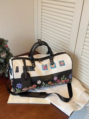 Flower Power large duffel bag in white and black with colorful floral print and camper van detail.