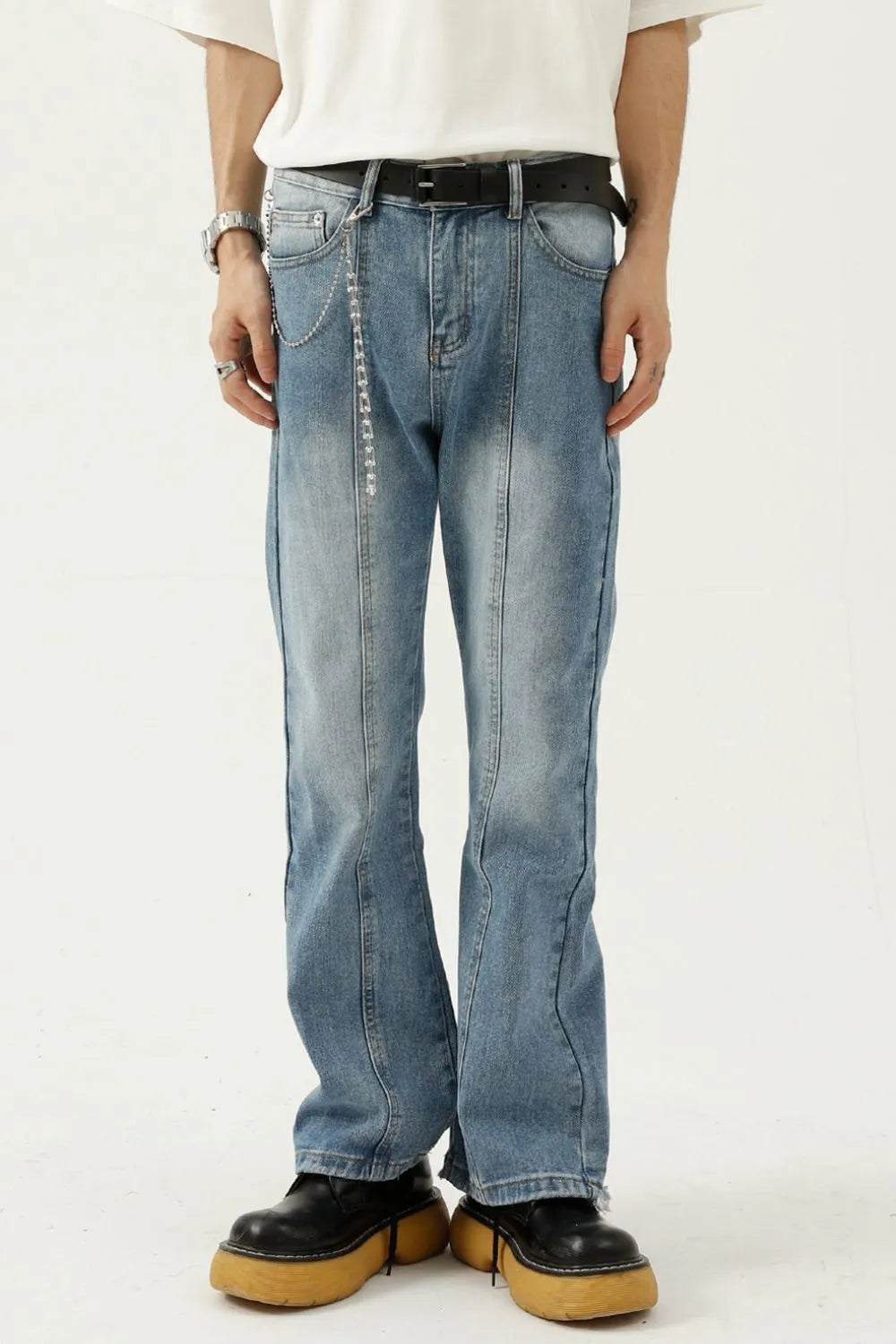 Medium wash denim flare jeans with seam detail and chain accessory