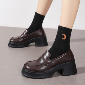 Dark brown round toe block heel loafers with chunky sole and black socks with moon detail