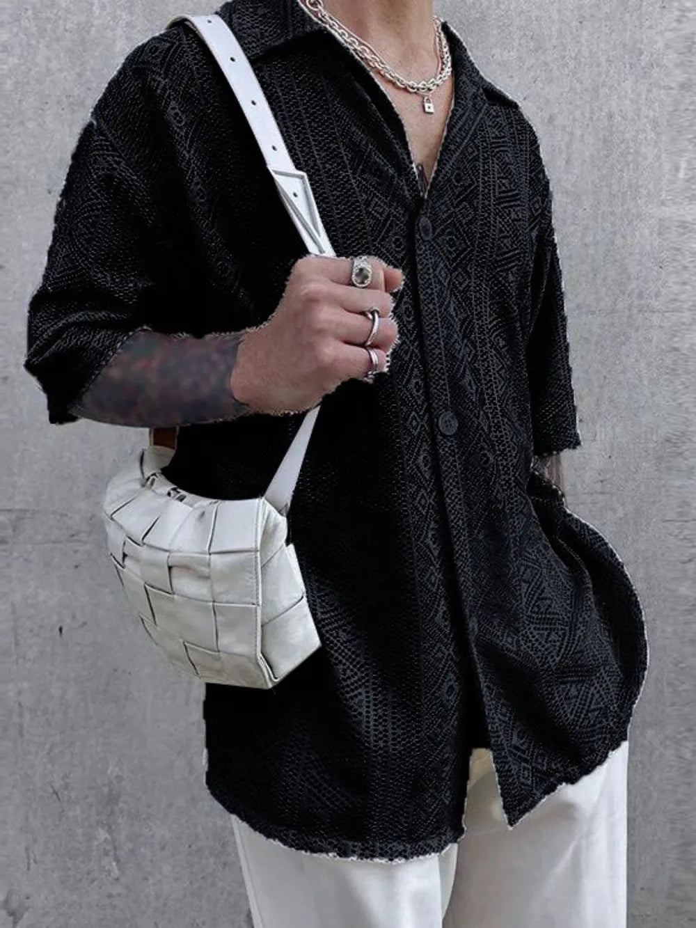 Black geometric crochet resort shirt with button-up front and short sleeves.