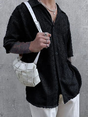Black geometric crochet resort shirt with button-up front and short sleeves.