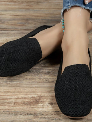 Black knit ballet flats with a textured pattern detail.