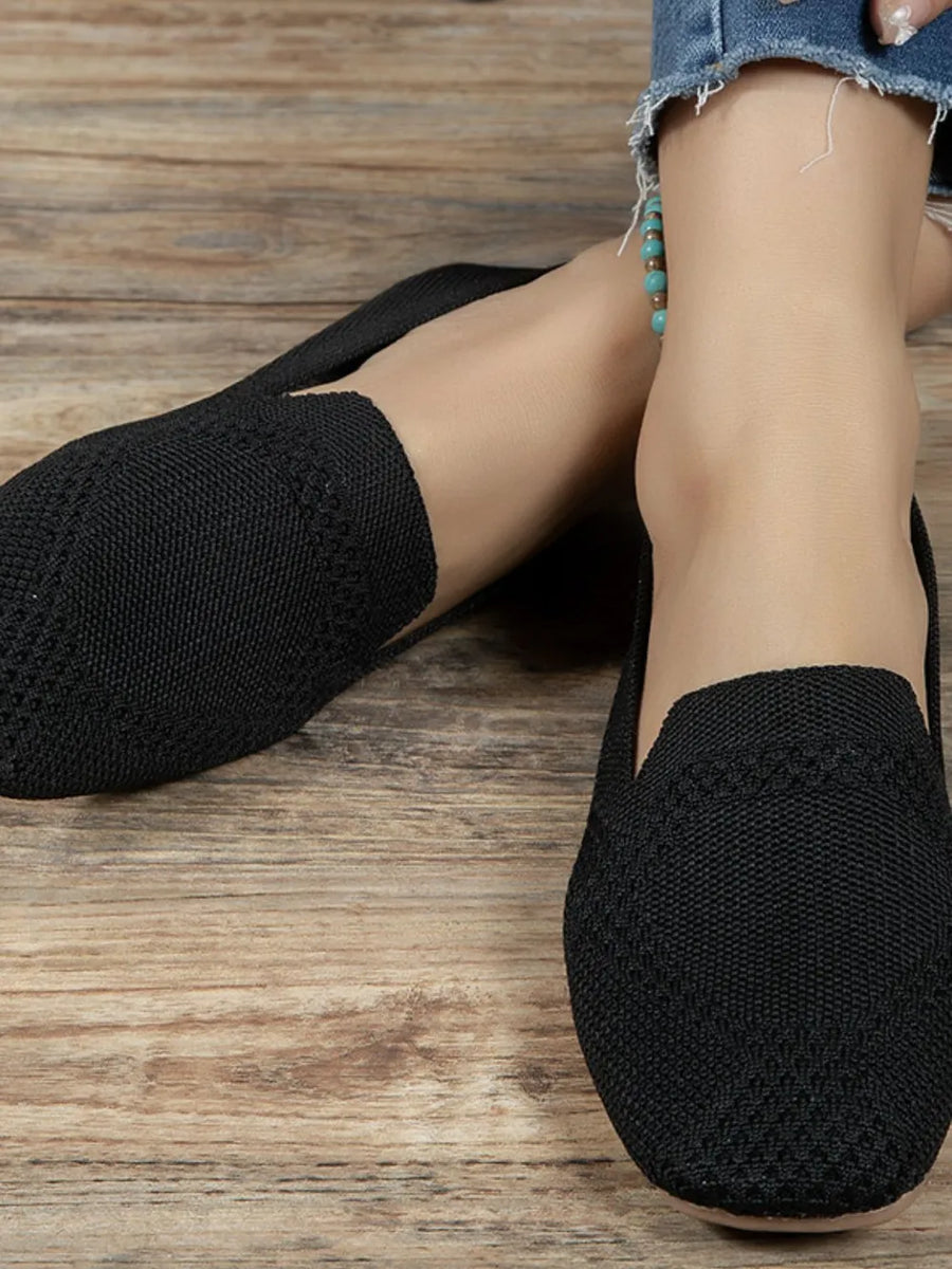 Black knit ballet flats with a textured pattern detail.