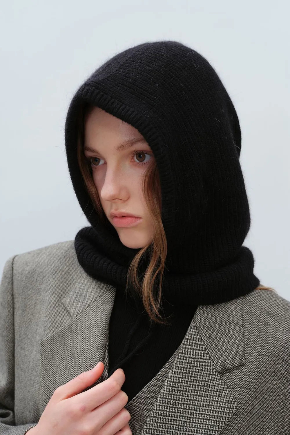 Black knit hooded balaclava with drawstring detail, worn with a blazer