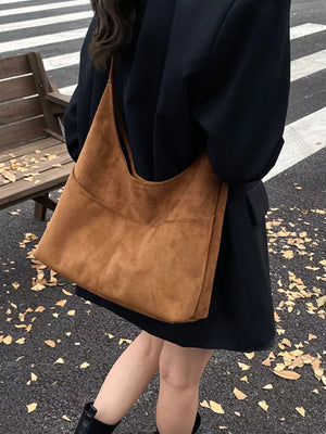 Large brown suede shoulder bag with a slouchy, minimalist design.