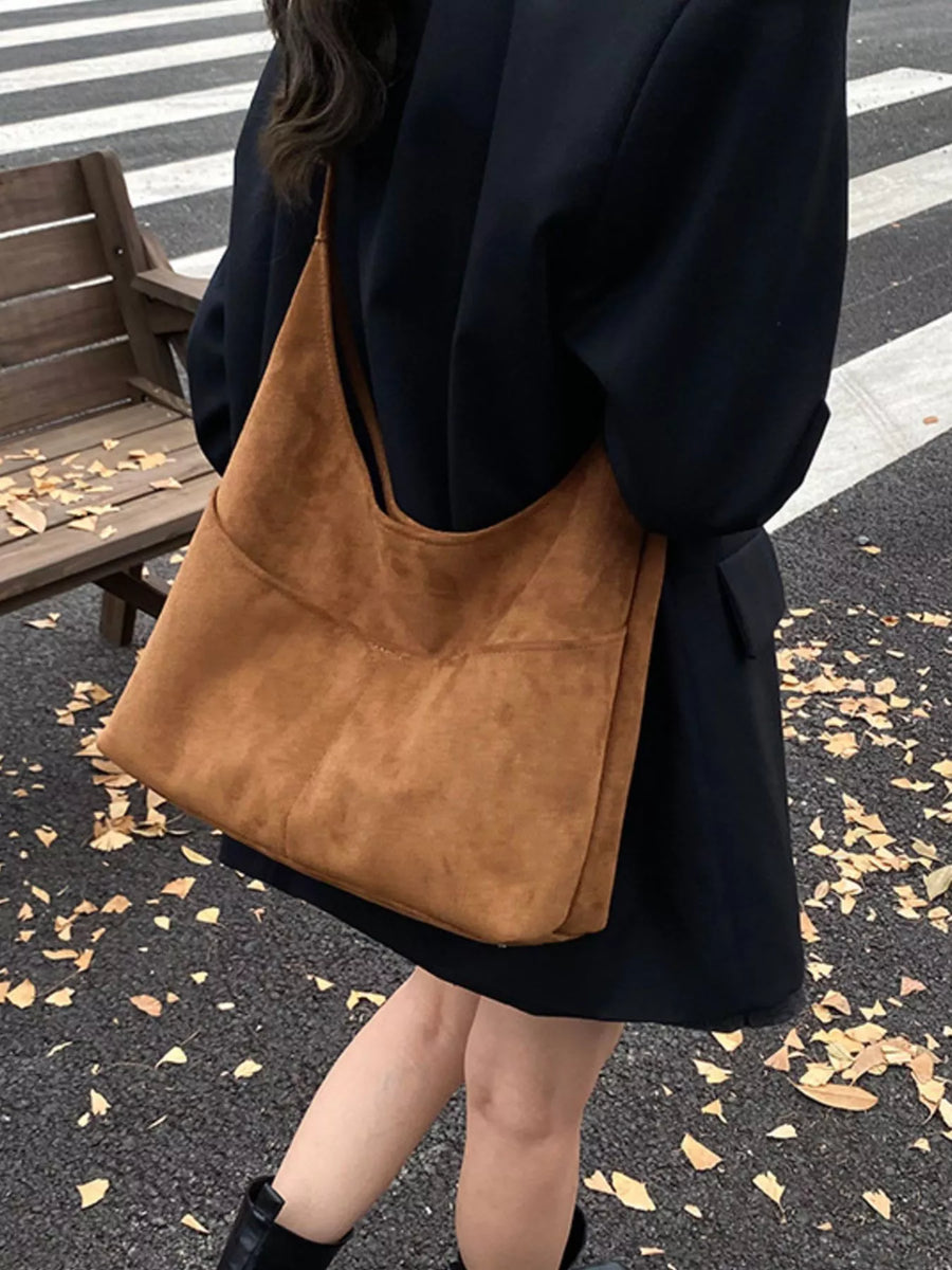 Large brown suede shoulder bag with a slouchy, minimalist design.