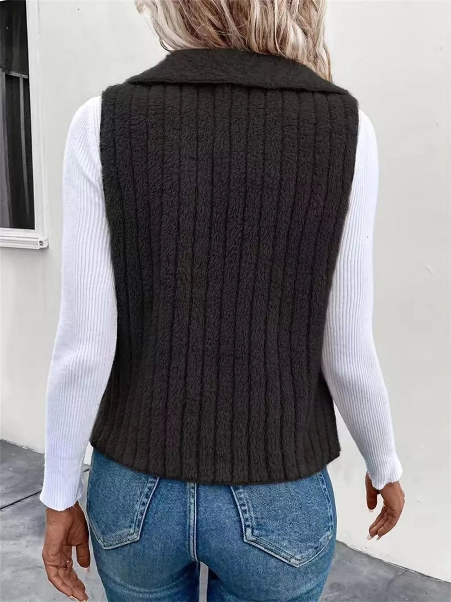 Cozy open front fleece vest in dark gray with vertical ribbing, styled over a white long-sleeve shirt.