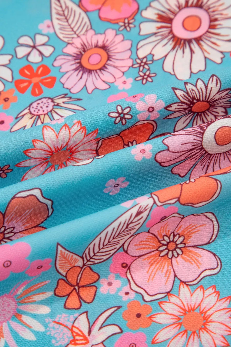 Maxi dress with vibrant bohemian floral print in pink, orange, and white on a blue background.