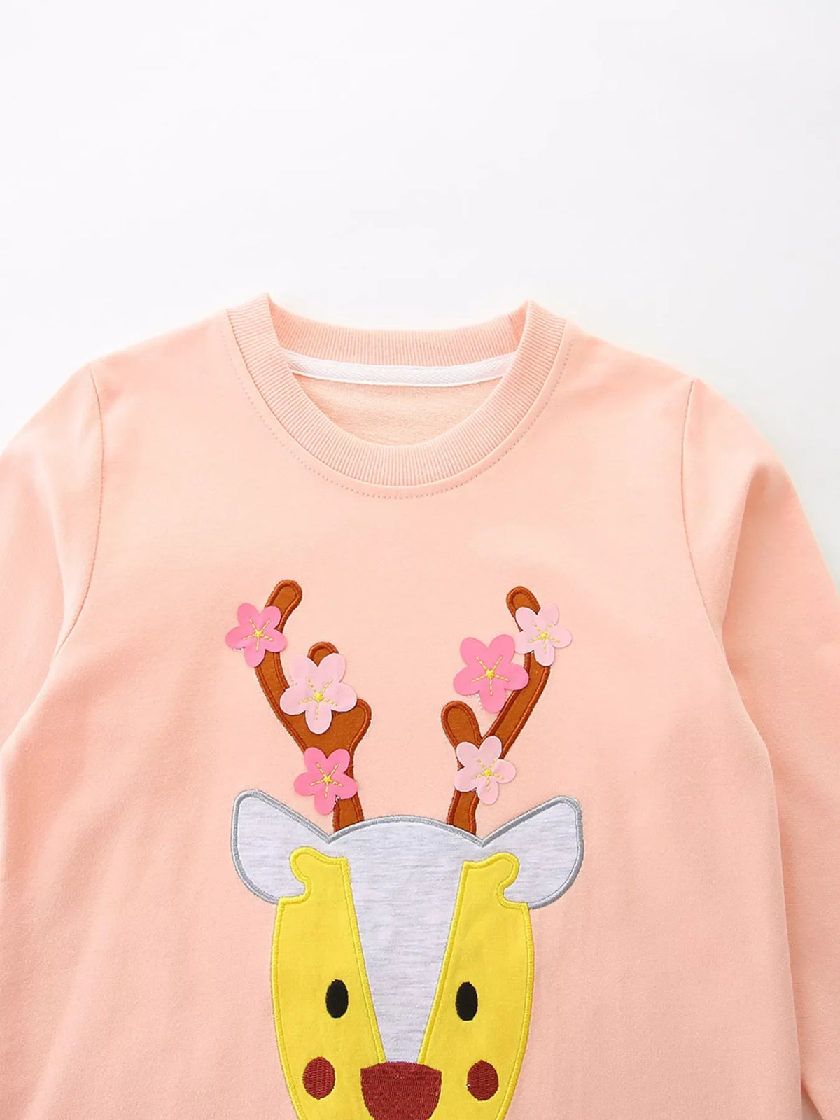 Watermelon pink cotton sweatshirt for kids with a reindeer applique and floral antlers.