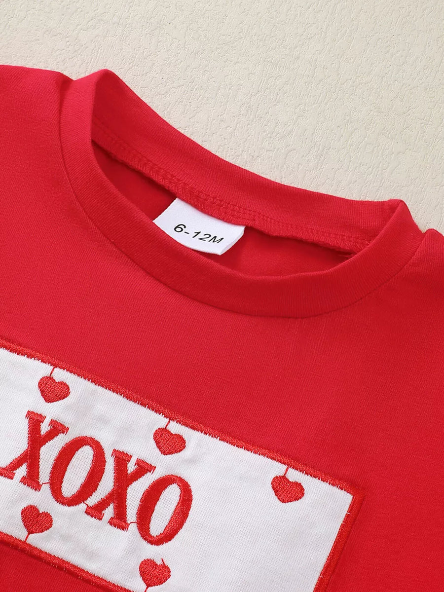 Red baby set with XOXO and heart embroidery detail on white patch.