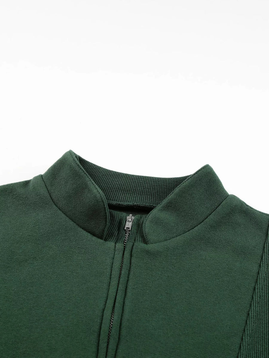 Dark green half zip sweatshirt with stand collar and ribbed details.