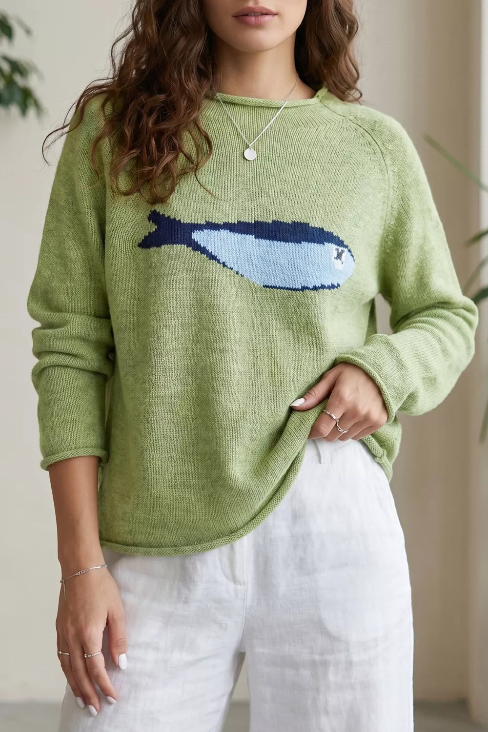 Green knit sweater with a blue and navy fish graphic, crew neck, and long sleeves.