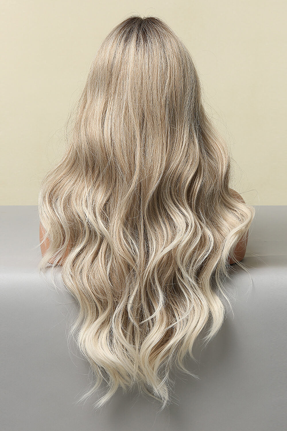 Ombre beach wave wig in light brown/blonde balayage with face framing layers.