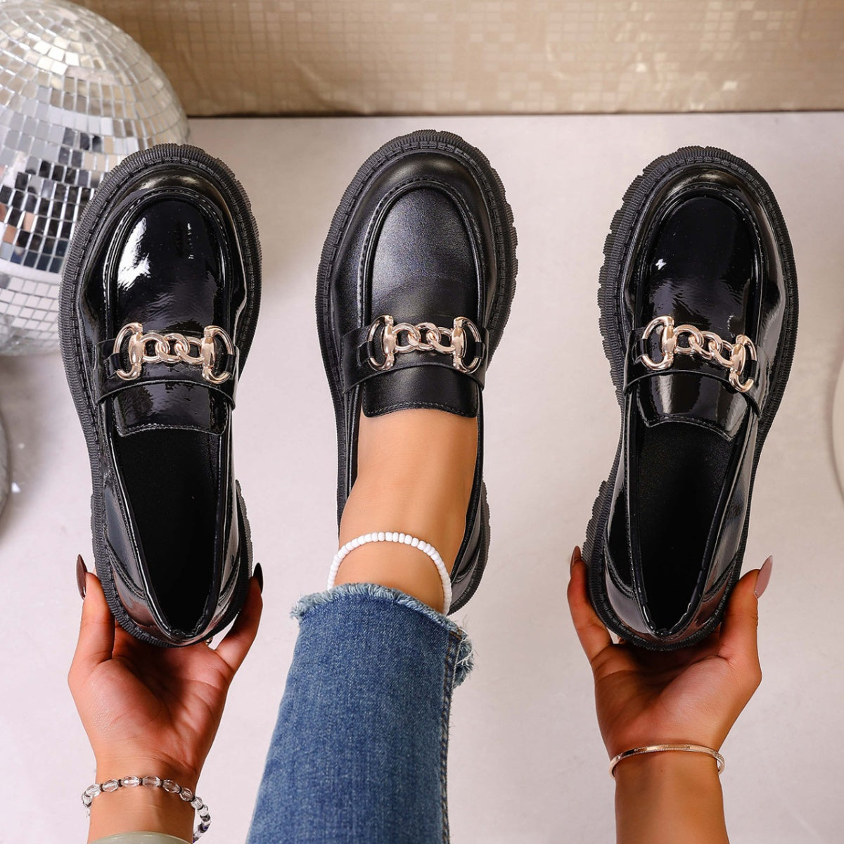 Chunky lug sole loafers in gloss black with chain detail.