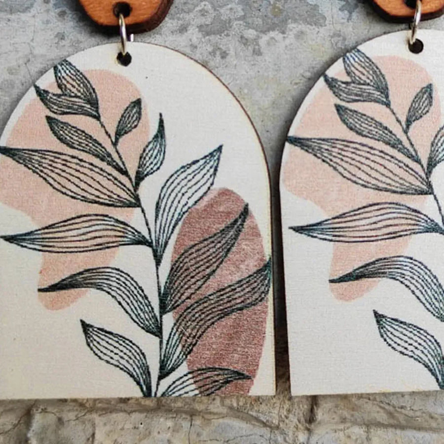 Botanical arch wood earrings in dusty pink with black line art leaves and abstract shapes.