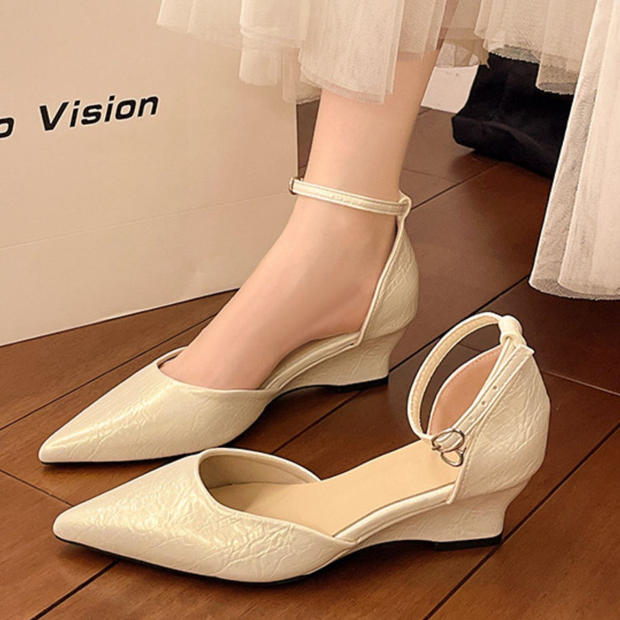 Beige pointed-toe ankle strap wedge shoes with adjustable buckle detail.