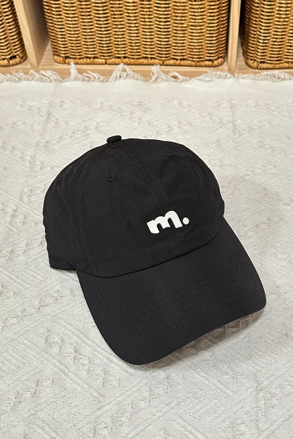 Black baseball cap with white embroidered m