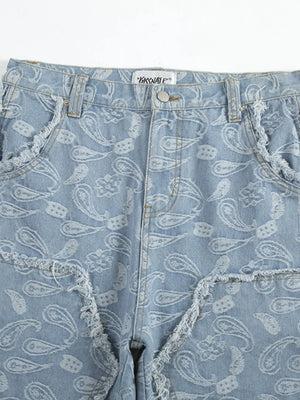 Light blue bootcut jeans with allover white paisley pattern and distressed frayed pockets.