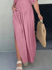Pink V-neck maxi dress with smocked waist, dolman sleeves, and side slits.