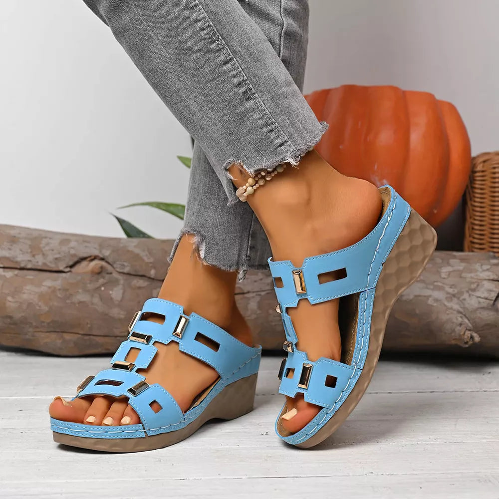 Sky blue open-toe wedge sandals with gold buckle details and comfortable cushioned sole.