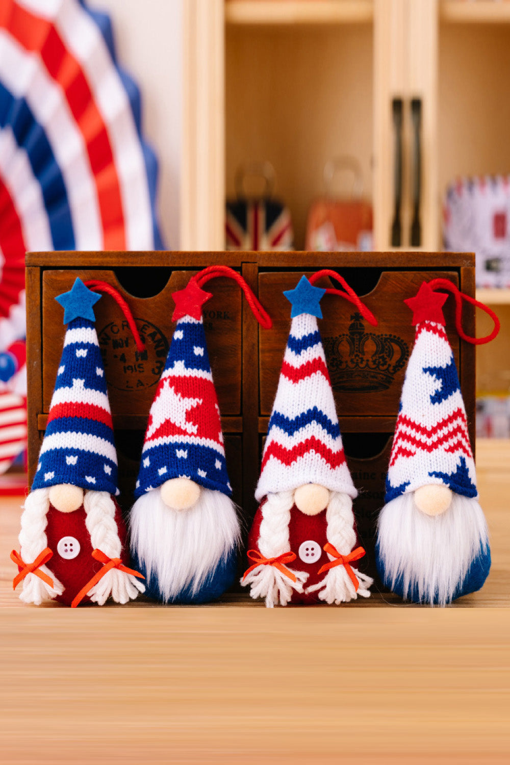 Patriotic knit gnome ornaments with red, white, and blue striped hats and star details.