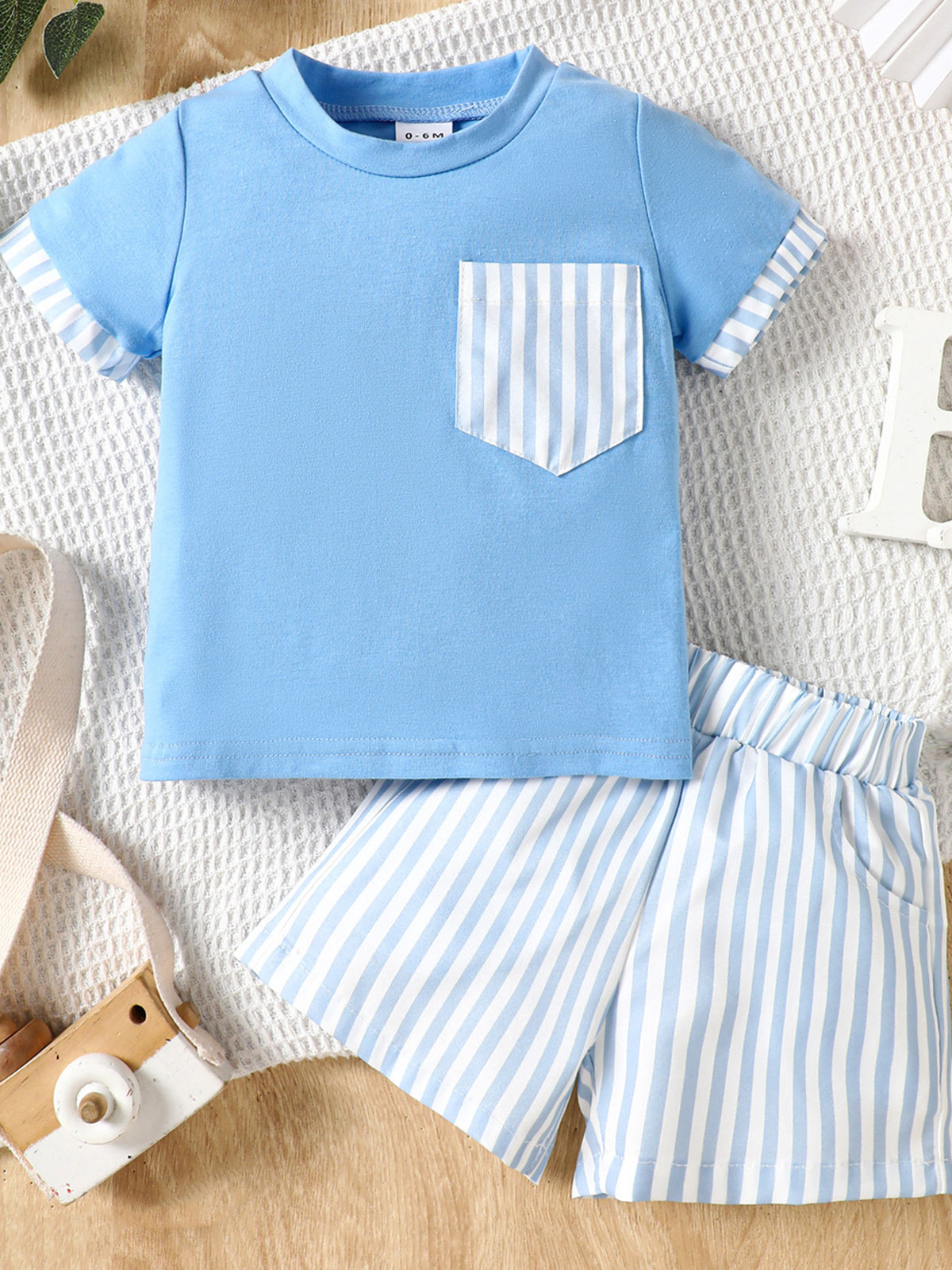Baby blue cotton tee with striped pocket and matching striped shorts.