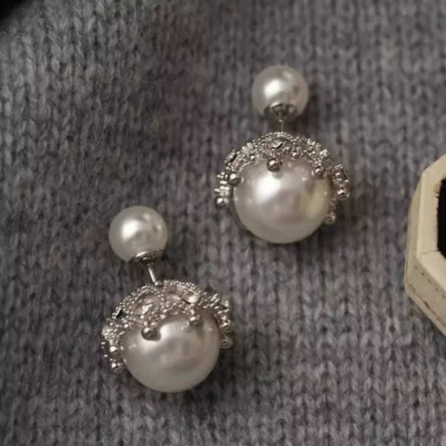 Pearl stud earrings with crown-inspired silver settings and small pearls.