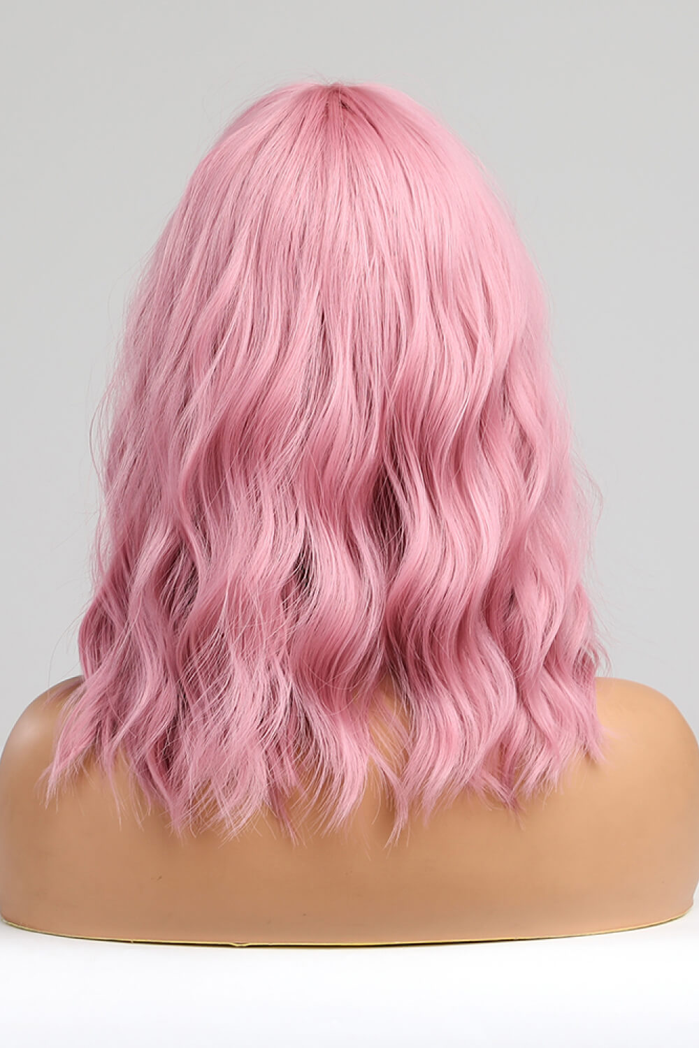 Pink bob wig with loose waves and bangs.
