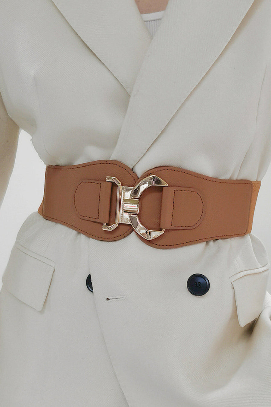 Caramel elasticated corset belt with sculpted alloy buckle, cinching a cream blazer.