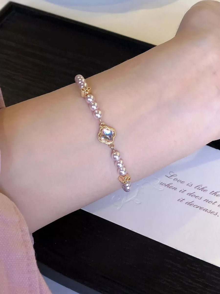 Delicate pearl bracelet with clover charm and gold accents