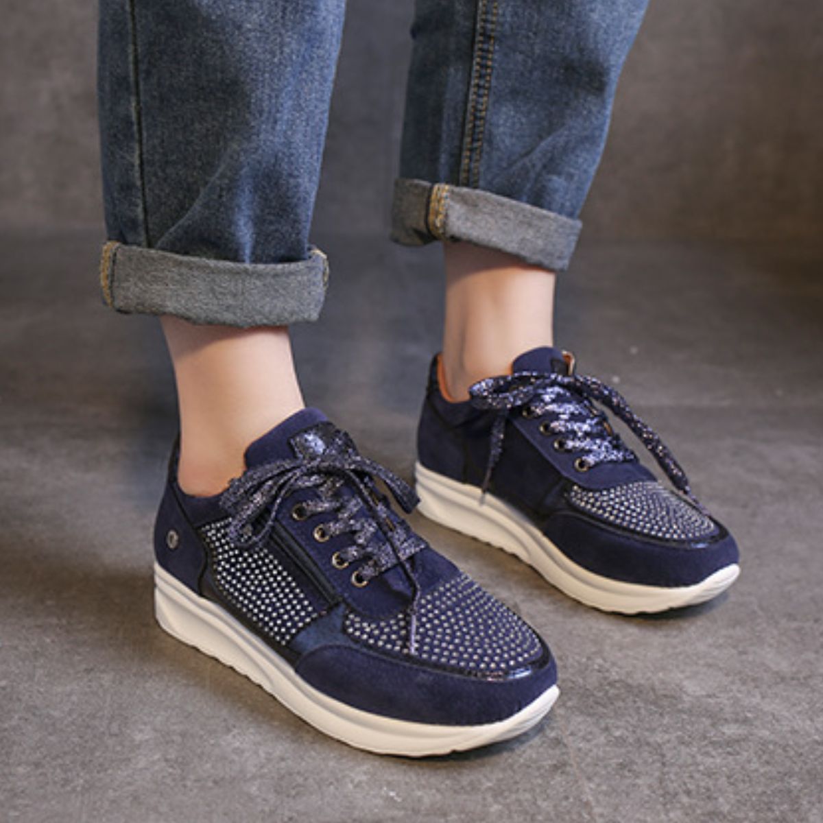 Blue lace-up sneakers with rhinestone embellishments and a chunky sole.